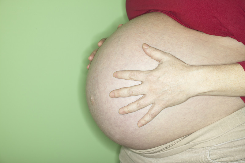 孕妇抱腹，中段，侧视图图片下载