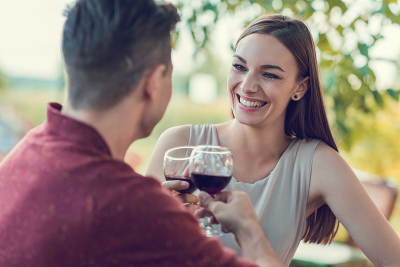 幸福的年轻夫妇用葡萄酒敬酒。图片下载
