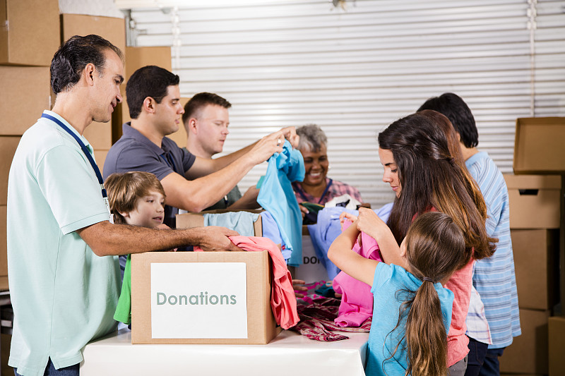 一群义工为有需要的家庭捐赠衣物。慈善机构。图片下载
