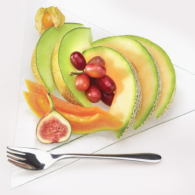 新鲜的混合切片水果放在盘子里图片素材