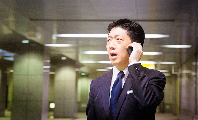 紧张的日本商人被手机上的可怕消息震惊图片下载