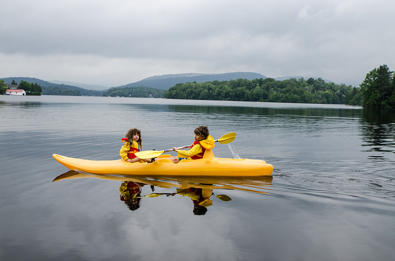 小男孩和小女孩在湖上划皮艇图片下载