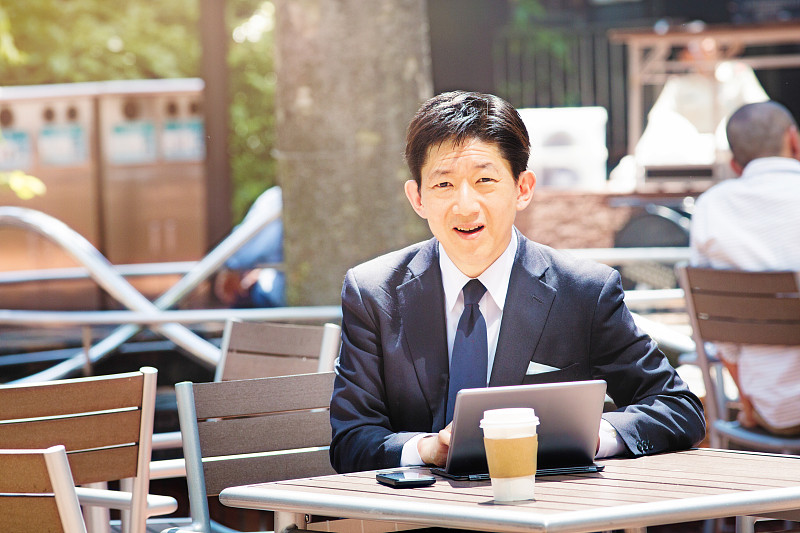 自信的日本求职者带着平板电脑在户外咖啡馆图片下载