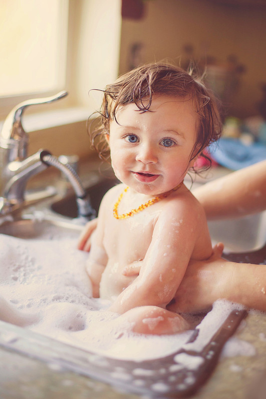 在水槽里洗头的卷发小孩图片下载