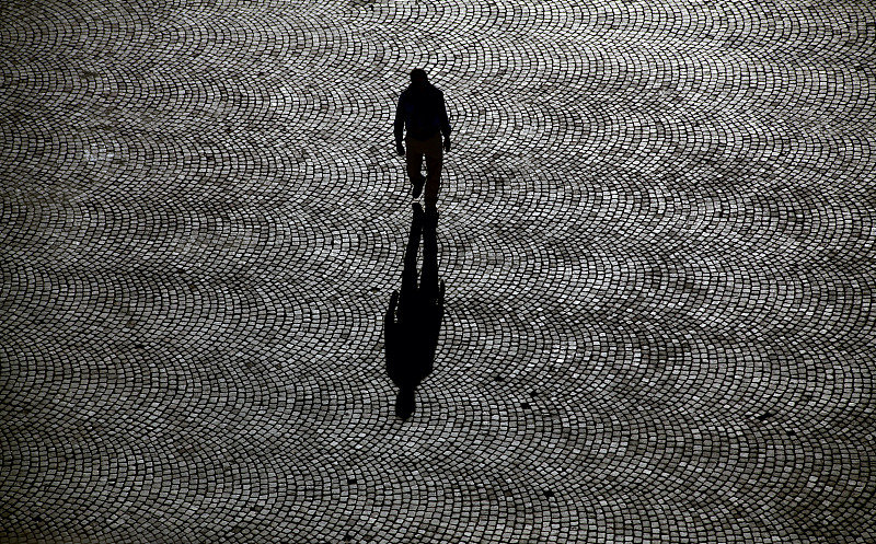 一个人独自走在铺满鹅卵石的街道上图片素材