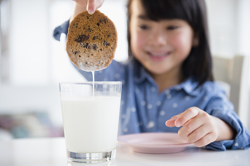 菲律宾女孩把饼干浸在牛奶里图片下载