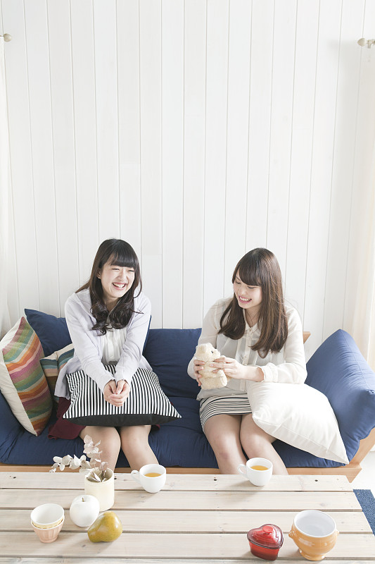 两个年轻女人坐在沙发上图片素材