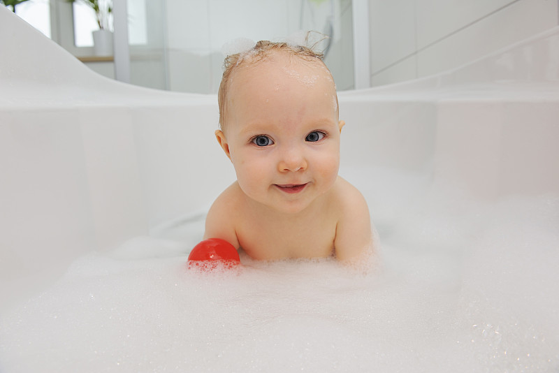 在浴缸里微笑的女婴的肖像图片下载