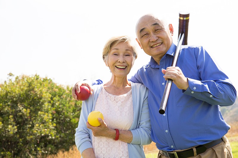 公园里一对老年夫妇的肖像，拿着槌球锤和球图片下载