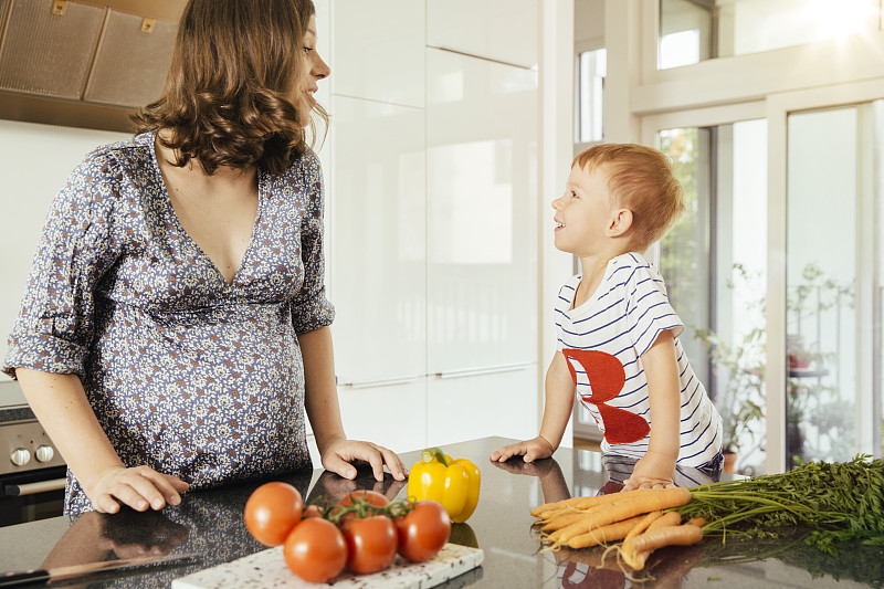 一个孕妇和她的小儿子在厨房里图片下载