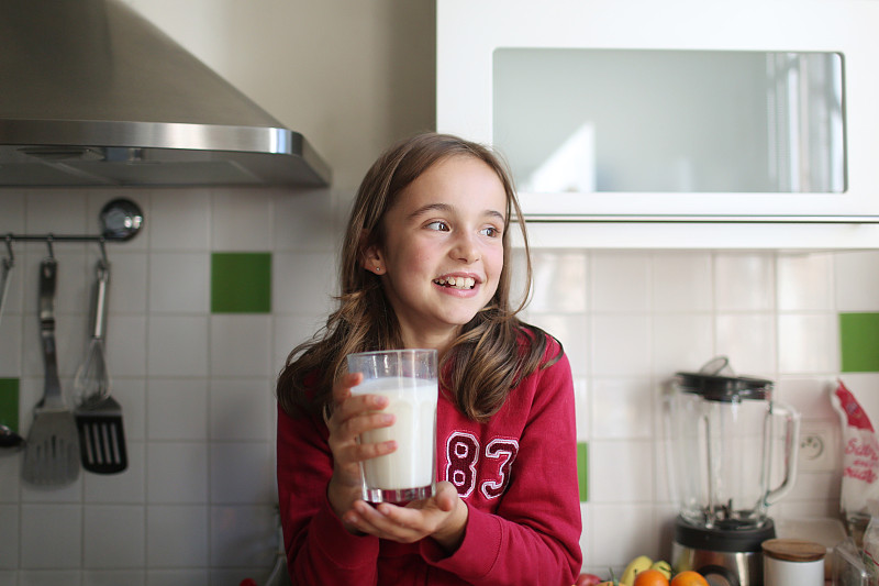 一个10岁的小女孩拿着一杯牛奶图片素材