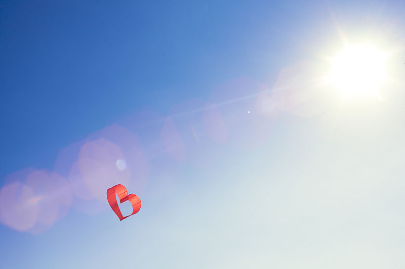 红心风筝或气球对抗蓝天。空气中弥漫着爱。图片下载