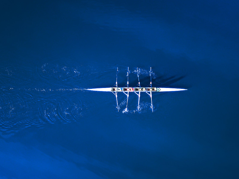 鸟瞰一艘划艇被经典的蓝色海水包围图片下载