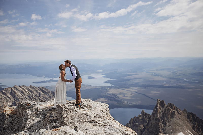 新郎和新娘在怀俄明州的山顶上接吻图片下载