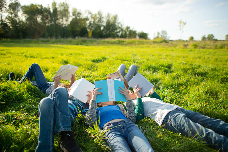 青年一起在草地上看书外库存照片摄影图片下载