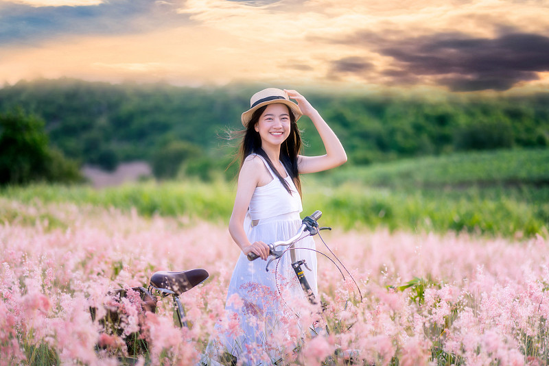 美丽无忧无虑的亚洲女人在草地。轻松、自由的工作风格图片下载