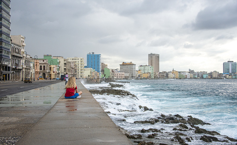 Malecón大街上的金发男孩在海堤上休息，哈瓦那老城，古巴图片下载