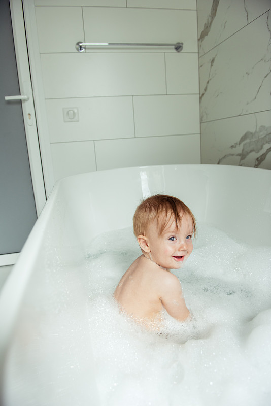 小男孩在泡沫浴缸里洗澡图片素材