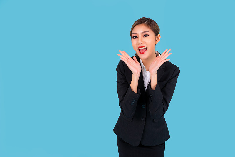 企业家漂亮年轻的亚洲女性，商业女性孤立的青色背景，哇和惊讶的商业女性的概念图片素材