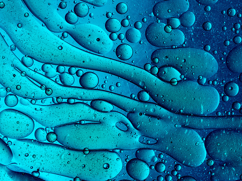 完整的框架抽象形状和纹理形成的气泡和滴油渍在蓝色液体背景。图片素材