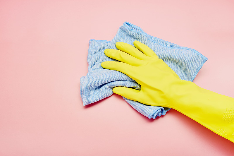 将黄色手套和抹布放在粉红色底色上，进行室内清洁图片下载