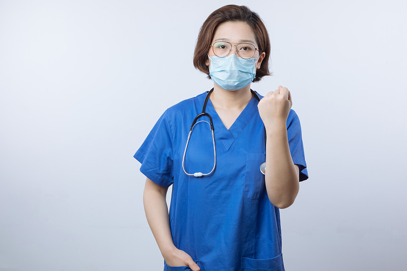 亚洲女医生戴着口罩握着拳头图片下载