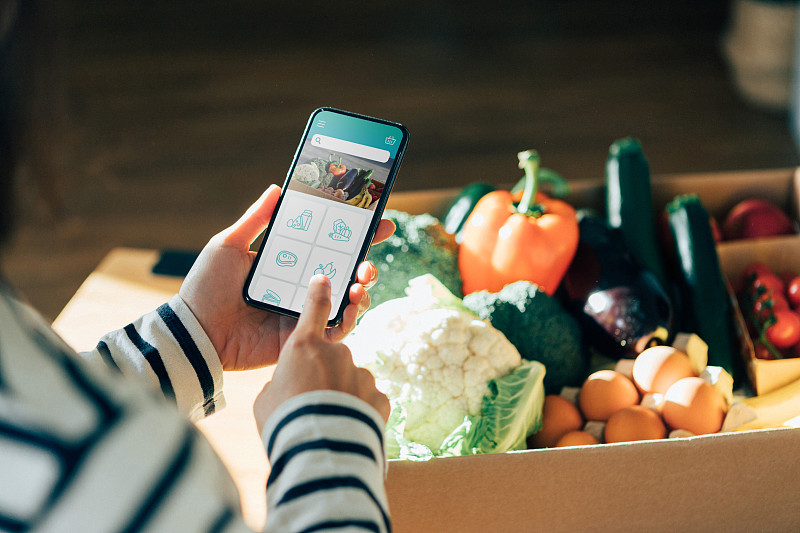 年轻女子用智能手机在网上订购食品杂货图片下载