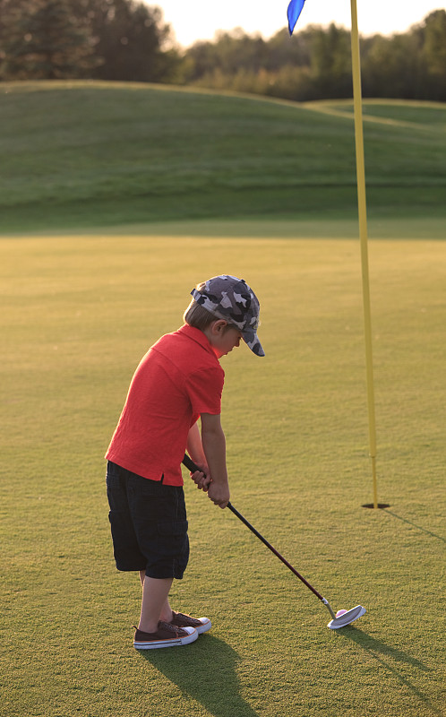 年轻的少年高尔夫球手在高尔夫球场上打球图片下载