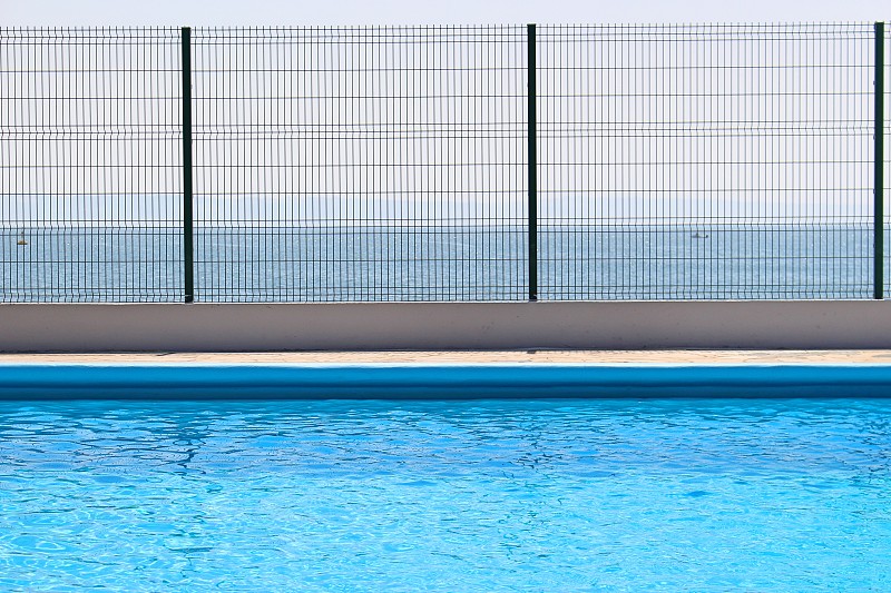 游泳池对着蓝色的大海图片素材