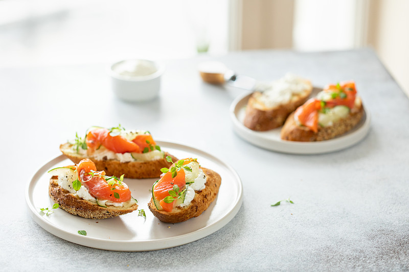 意式烤面包配鲑鱼、凝乳芝士和黄瓜，以白色为背景。图片素材
