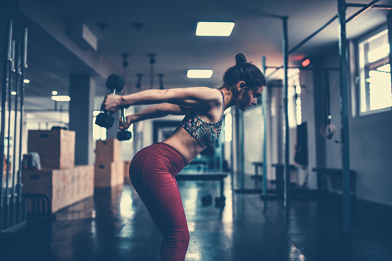女性在健身房用哑铃锻炼肱三头肌图片下载