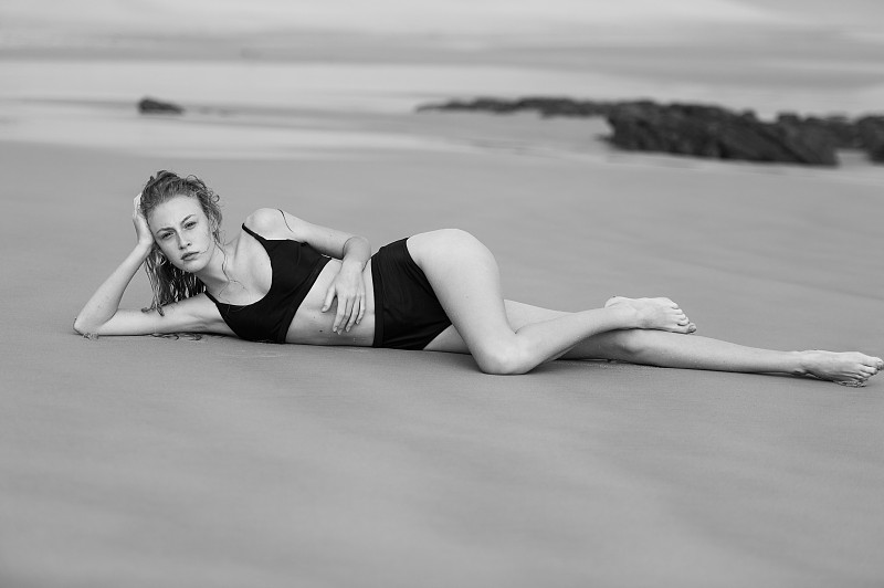 穿着比基尼躺在海滩上的女人图片素材