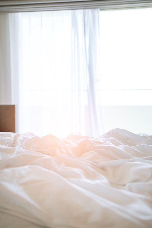早晨的阳光透过窗户照在床上图片素材