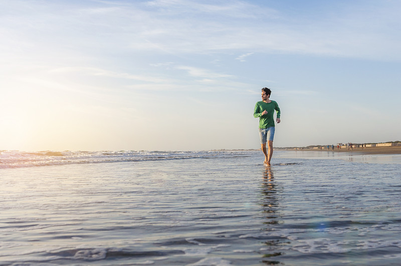 日出时，西班牙大加那利岛的大海上奔跑的人图片下载
