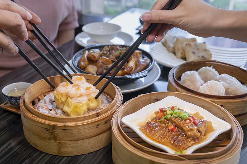 人们在餐馆里用筷子吃广东dum sum图片素材