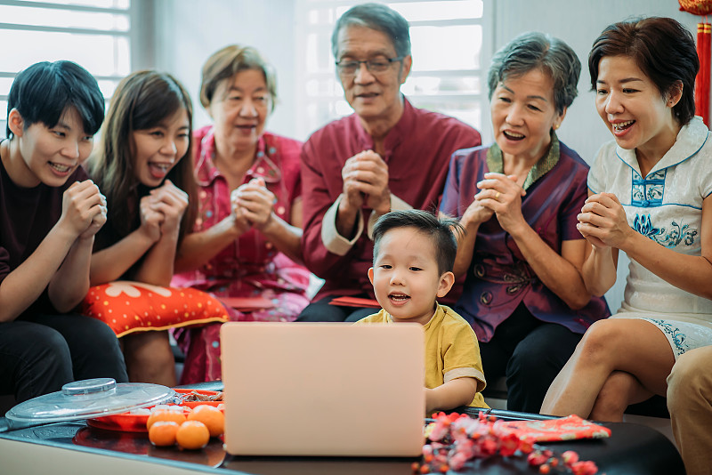 春节期间，亚洲华人通过笔记本电脑在客厅进行多代家庭视频会议图片下载