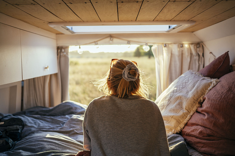 一个站在露营车后面看风景的女人图片素材