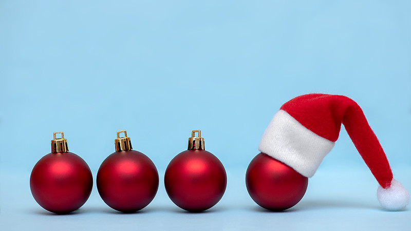 圣诞树球与圣诞老人帽子的蓝色背景，复制空间图片下载