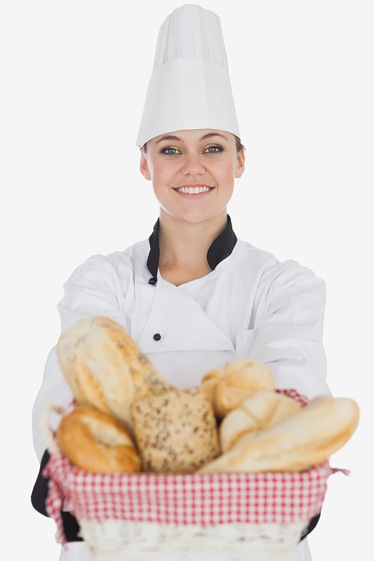 快乐的年轻女厨师拿着面包篮图片素材