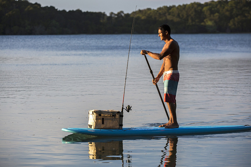 年轻人与他的渔具站在一个桨登郊游图片素材