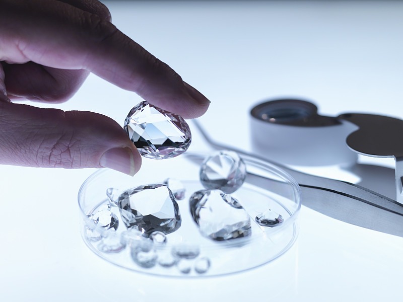 Jeweller inspecting replica diamonds图片素材