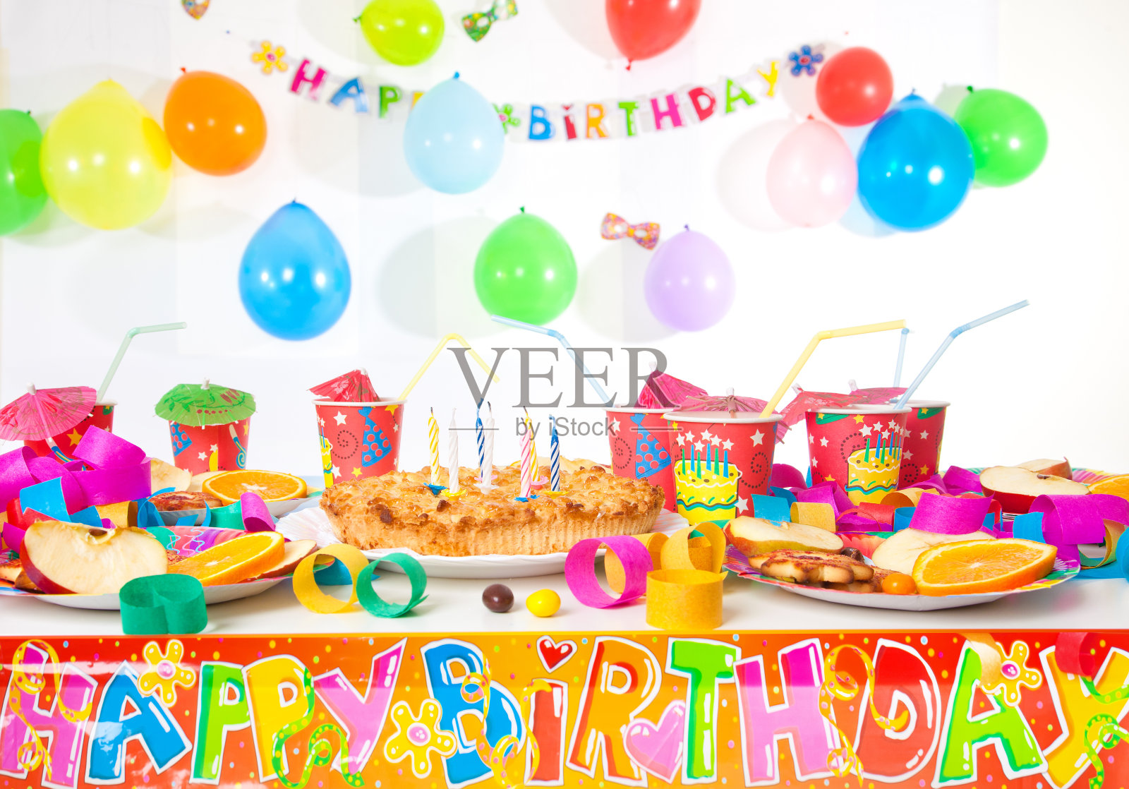 有盘子、杯子、装饰品和蛋糕的生日桌子照片摄影图片
