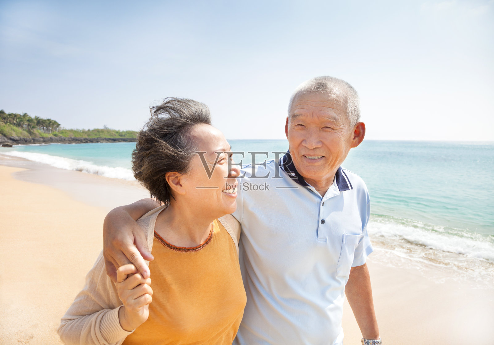快乐的亚洲老人在海滩上散步照片摄影图片