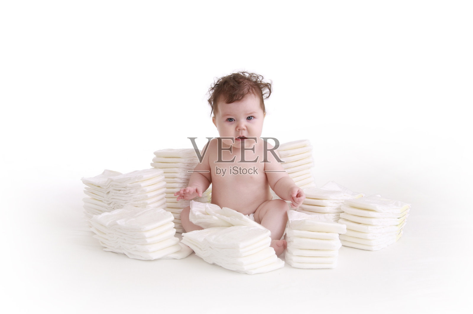 卷头发的婴儿坐在一堆尿布里照片摄影图片