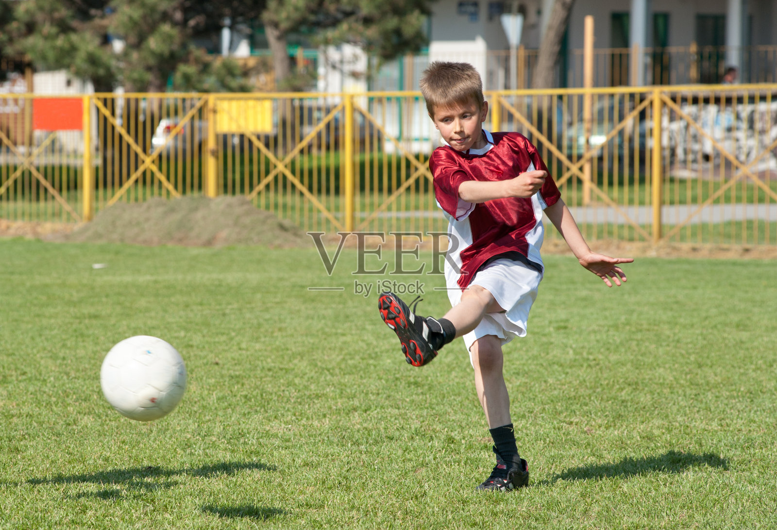 小男孩踢足球照片摄影图片