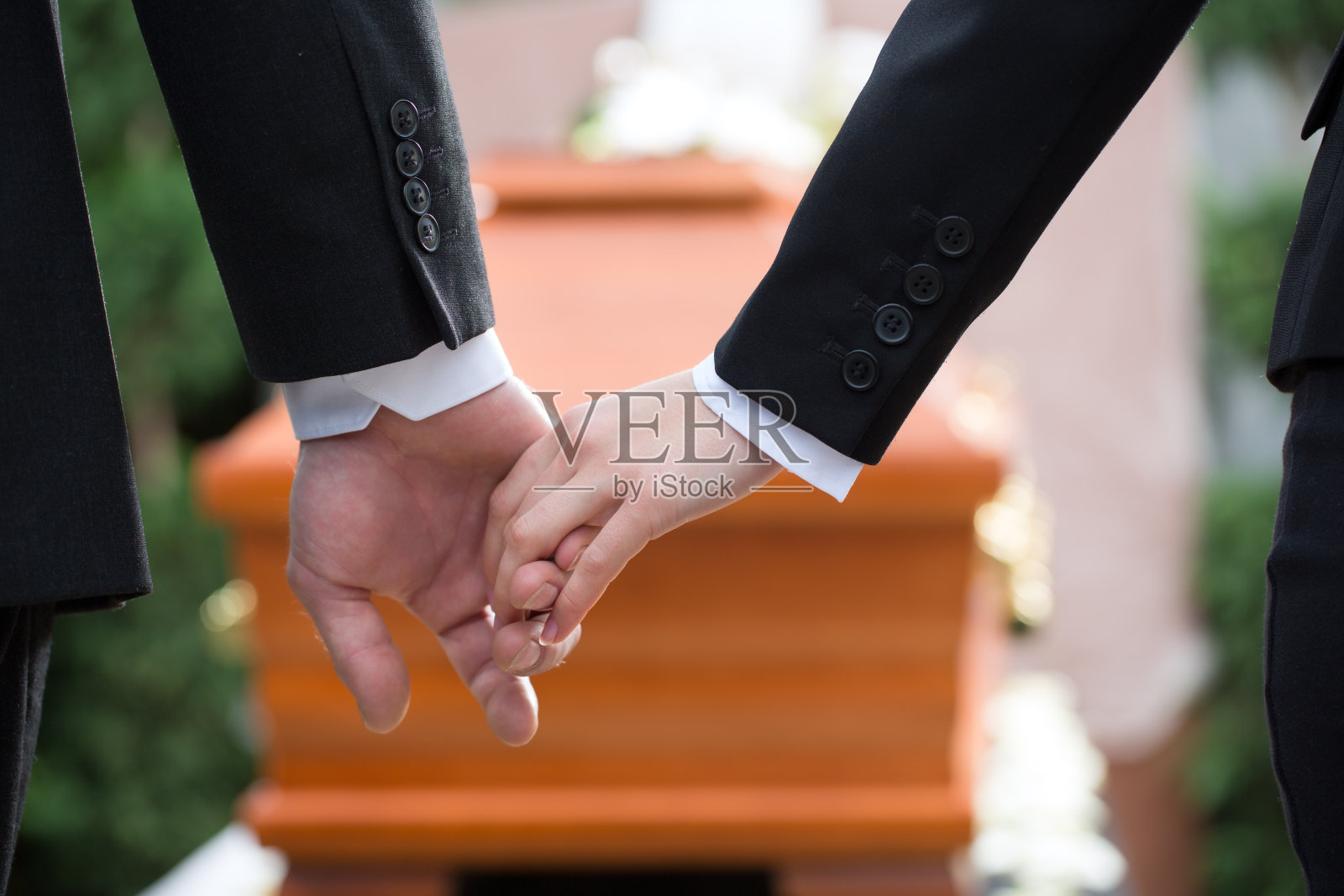 葬礼上两个人手牵着手照片摄影图片