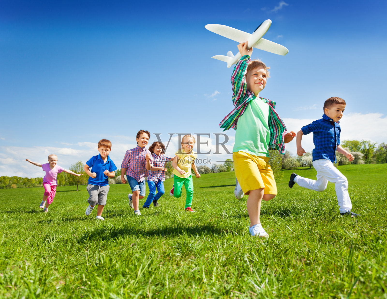 积极奔跑的孩子与男孩拿着飞机玩具照片摄影图片