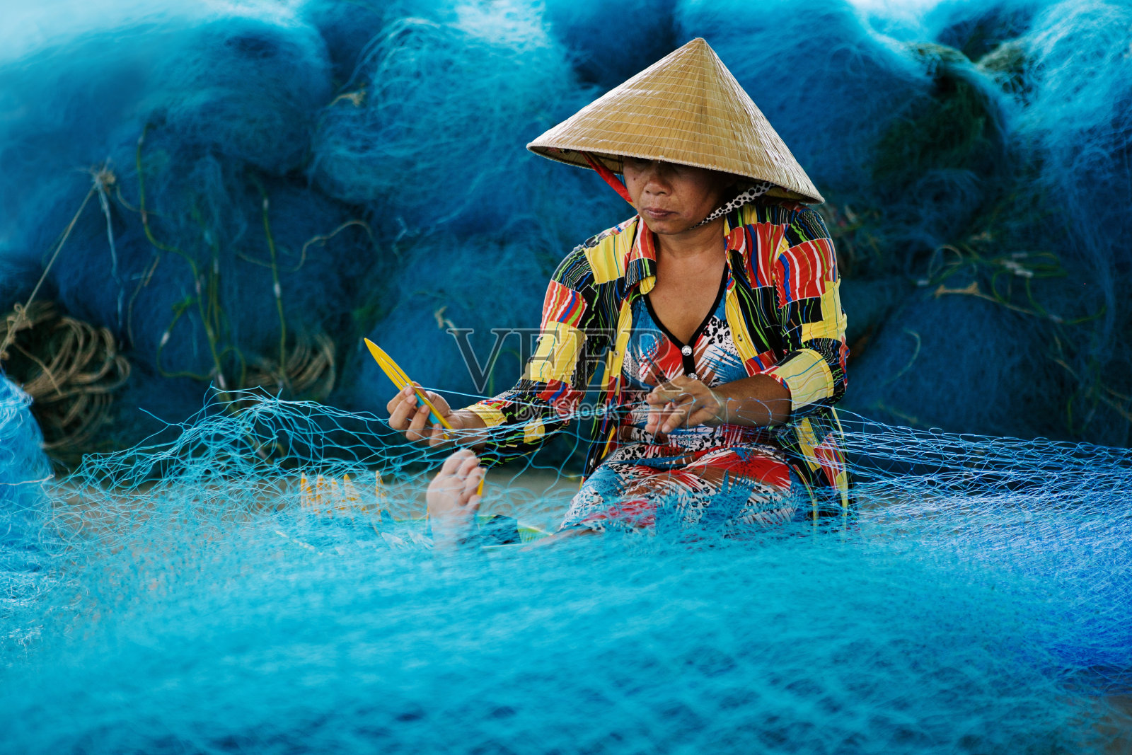 越南湄公河三角洲北寮的渔网修补工作照片摄影图片