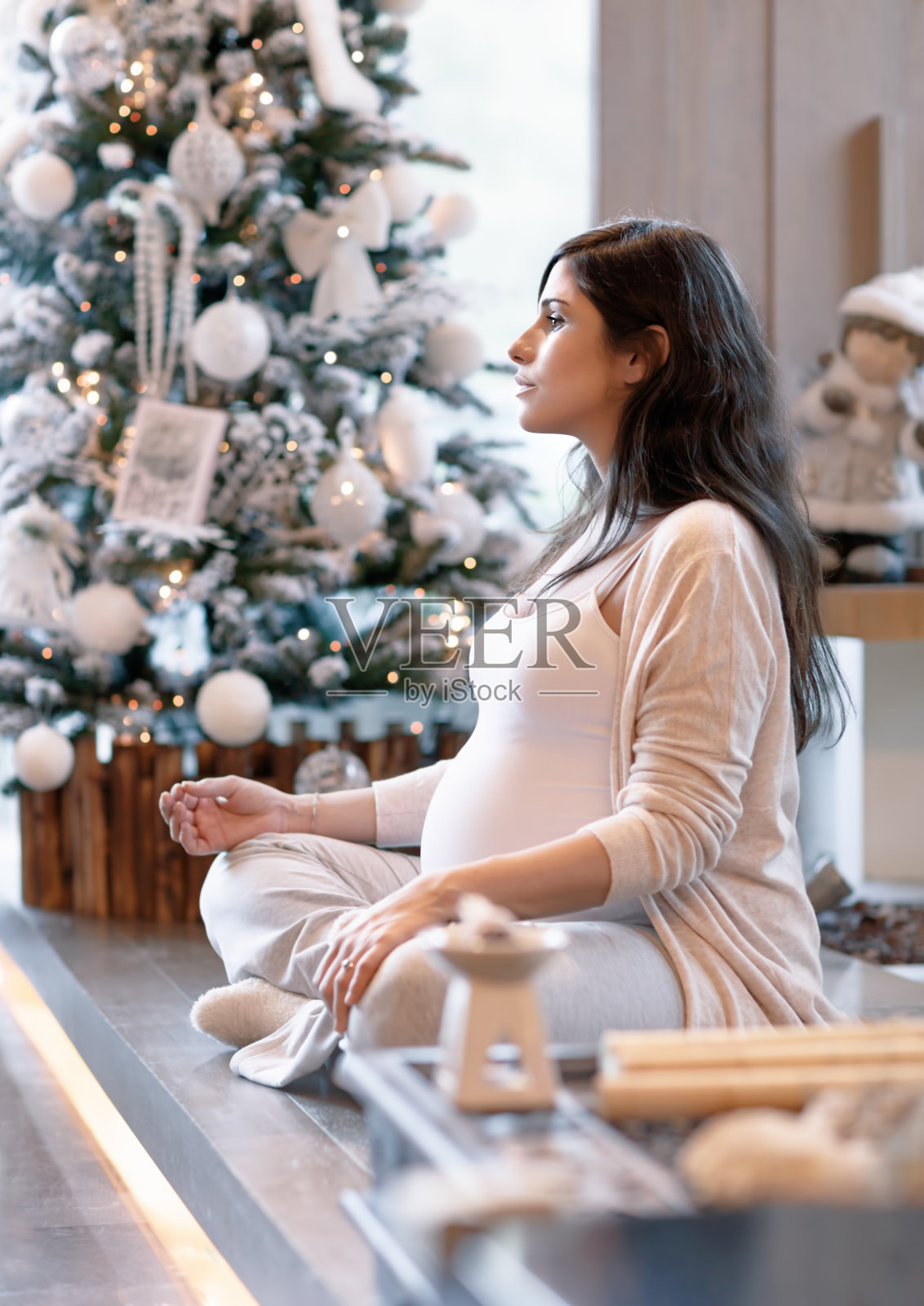 一名孕妇在圣诞树旁照片摄影图片