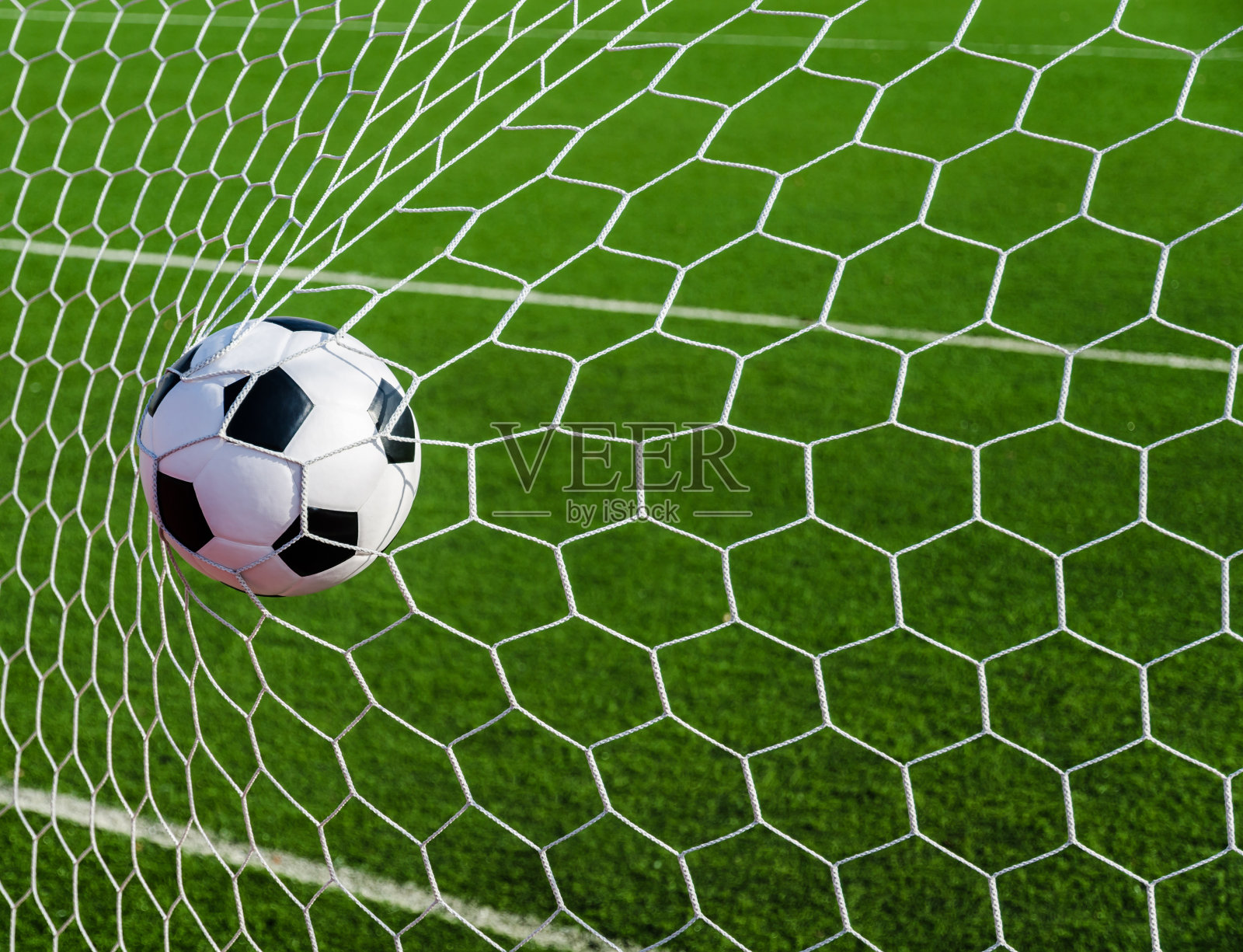 足球足球在球门网与绿色草地的领域。照片摄影图片